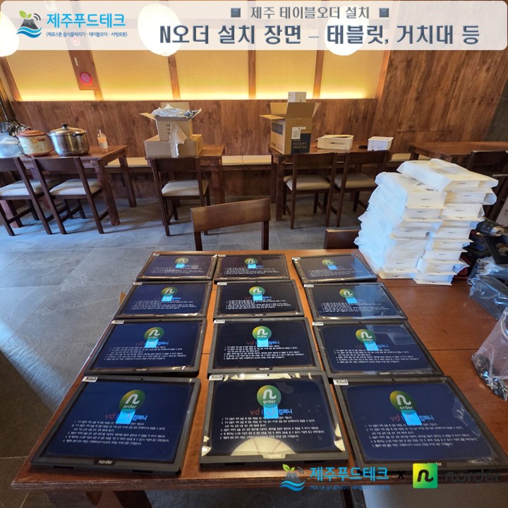 오렌찌 N오더 설치사례 현장에서 후불형 테이블오더 태블릿과 거치대를 테이블 위에 정리해 설치 준비 중인 사진