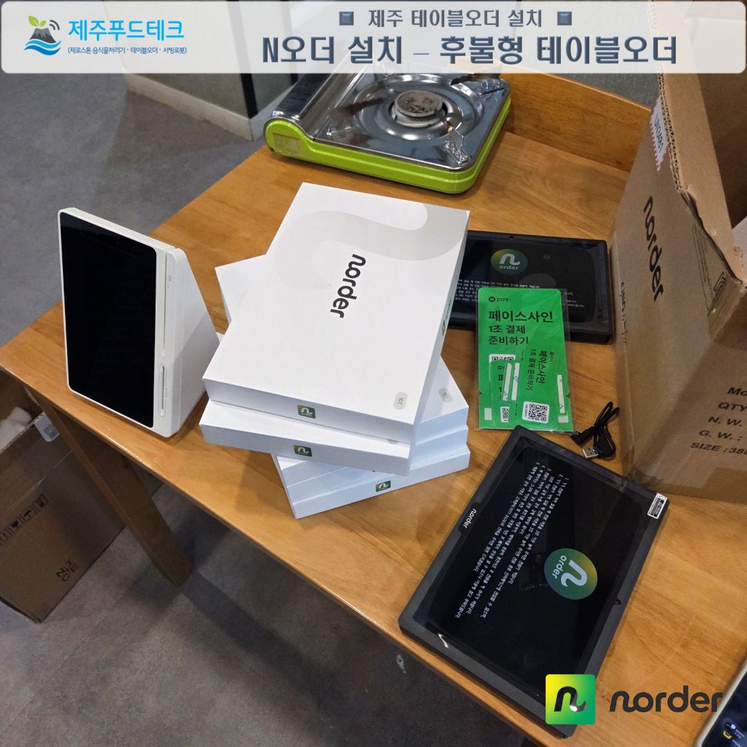 제주푸드테크가 제주뼈앤찜 테이블 위에 N오더 후불형 태블릿과 포장 상자를 풀어 놓은 설치 장면