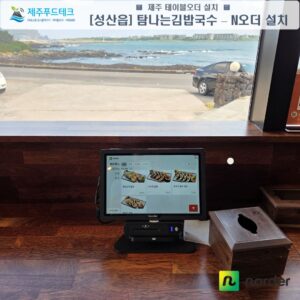 바다가 보이는 탐나는김밥국수 창가 좌석의 N오더 선불형 태블릿과 카드리더기